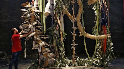 El artista rosarino Carlos Herrera con su instalación realizada con plantas, ropa y huesos en arteba Focus 2017