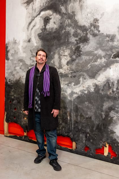 El artista Tomás Espina frente a su obra, que forma parte de la exposición "Cien caminos en un solo día", con curaduría de Jimena Ferreiro