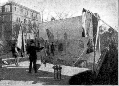 El artista trabajando en el jardín de su taller. A la izquierda, su modelo portando la imitación del estandarte real.