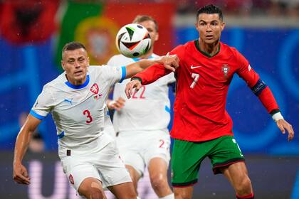 El atacante portugués Cristiano Ronaldo (derecha) pugna el balón con el checo Tomas Holes en el partido por el Grupo F de la Eurocopa, el martes 18 de junio de 2024, en Leipzig. (AP Foto/Petr Josek)