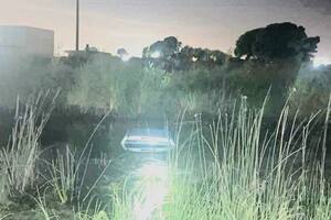 El auto, volcado en el canal de la Ruta 11