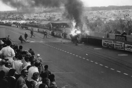 El automóvil de Pierre Levegh arde a un costado de la pista, en un accidente que tuvo un saldo de 84 fallecidos; las 24 Horas de Le Mans de 1955 fueron la carrera más trágica de la historia.