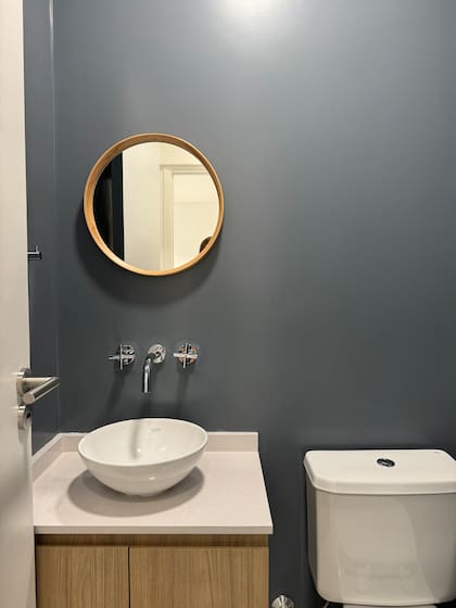 "El azul, en contacto con la cocina, le aporta incluso más vida a ese sector”. Paredes (en el tono Waterloo de Sherwin Williams) y espejo (Magnolias deco). Mueble (diseñado y ejecutado por el estudio, en Melamina Camellia de Faplac).
