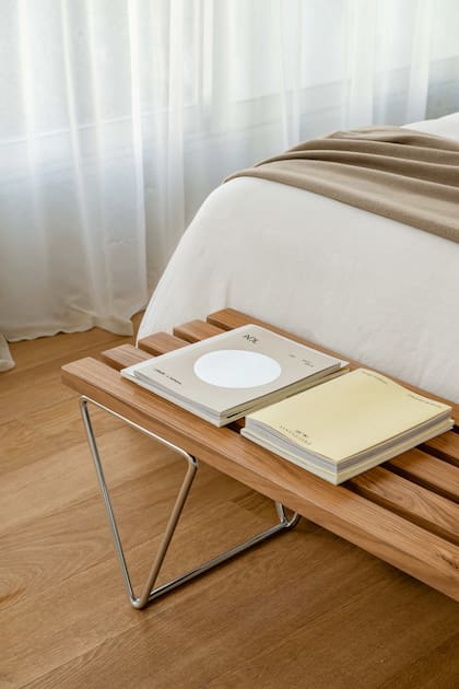 El banco de madera y acero inoxidable introduce una cuota de calidez y funciona como un gesto decorativo tan simple como efectivo.