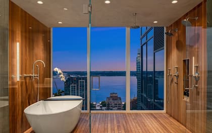 El Baño en suite cuenta con revestimientos de madera y mármol, una bañera junto a la ventana y una ducha de diseño