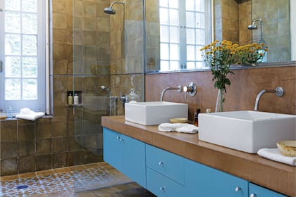 El baño está revestido en calcáreos y cerámicos, y el mueble fue laqueado a tono con estos últimos.