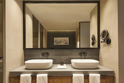 El baño privado de la suite está equipado con ducha de hidromasaje, doble lavabo y y revestimientos en tonos neutros