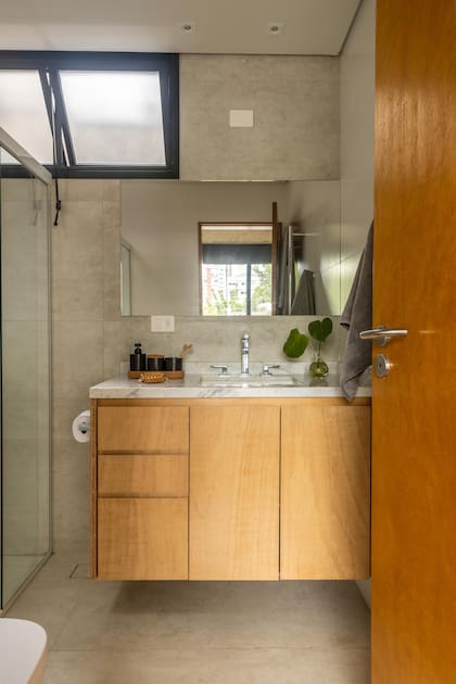 El baño sigue el mismo lenguaje material del dormitorio.