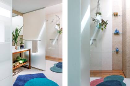 El baño tiene divisiones parciales hechas con mamparas esmeriladas y transparentes. alfombras (Las Martas). cuencos esmaltados en marfil y azul (Salazar Casa). Plantas colgantes en maceta (Pasionarias del Bajo).