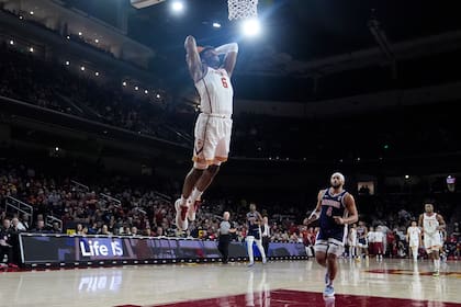 El base de la Universidad del Sur de California Bronny James clava el balón frente al base de l Arizona Kylan Boswell en un juego colegial el sábado 9 de marzo del 2024. (AP Foto/Marcio Jose Sanchez)