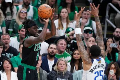 El base de los Celtics de Boston, Jrue Holiday realiza un tiro sobre el escolta de los Mavericks de Dallas, P.J. Washington (25) durante la primera mitad del Juego 2 de las Finales de la NBA, el domingo 9 de junio de 2024, en Boston. (AP Foto/Steven Senne)