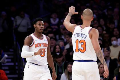 El base de los Knicks de Nueva York RJ Barrett felicita a su compañero Evan Fournier durante la segunda mitad del partido de la NBA contra los Bulls de Chicago, el lunes 28 de marzo de 2022, en Nueva York. (AP Foto/Adam Hunger)