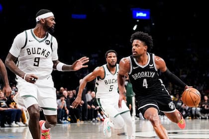 El base de los Nets de Brooklyn Dennis Smith Jr. avanza hacia la canasta frente al alero de los Bucks de Milwaukee Bobby Portis en el encuentro del miércoles 27 de diciembre del 2023. (AP Foto/Peter K. Afriyie)
