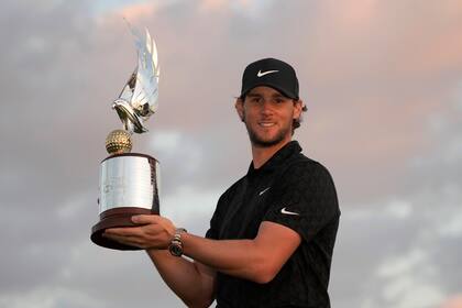 El belga Thomas Pieters sostiene el trofeo tras ganar el Campeonato de Abu Dhabi en el Yas Links Golf Course el domingo 23 de enero del 2022. (AP Foto/Kamran Jebreili)
