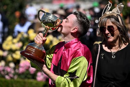 El beso de Robbie Dolan al trofeo de la Melbourne Cup, mientras sonríe Sheila Laxon, la entrenadora de Knisght's Choice, el ganador de la carrera.