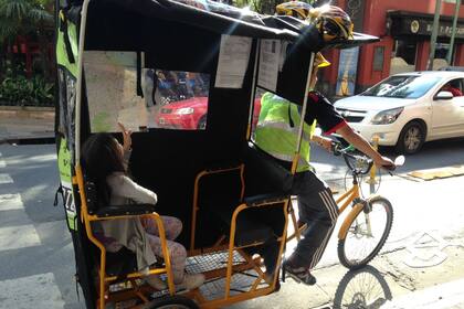 El bicitaxi, en la ciclovía de Montevideo, con una joven pasajera