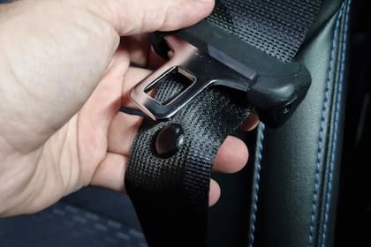 El botón del cinturón de seguridad que guía a la hebilla