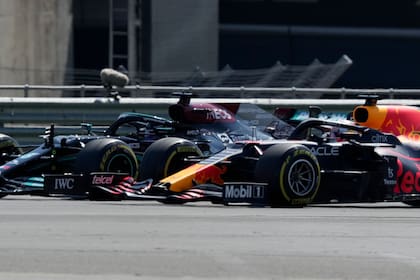 El británico Lewis Hamilton, izquierda, de Mercedes, y el holandés Max Verstappen, de Red Bull, toman una curva mientras pelean por la punta al inicio del Gran Premio Británico de la Fórmula Uno, en el circuito de Silverstone, Inglaterra, el domingo 18 de julio de 2021. (AP Foto/Jon Super)