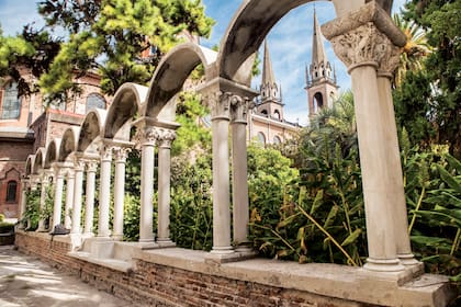 Claustro de la abadía de San Benito Abad y detrás, las agudas torres de la iglesia homónima