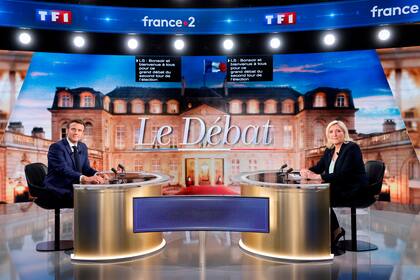 El candidato de centro y presidente francés Emmanuel Macron y la contendiente de extrema derecha Marine Le Pen posan antes de un debate televisado el miércoles 20 de abril de 2022, en La Plaine-Saint-Denis, en las afueras de París. (Ludovic Marin, Pool vía AP)
