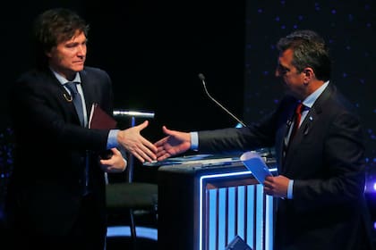 El candidato libertario Javier Milei saluda a Sergio Massa al finalizar el segundo debate presidencial (Photo by AGUSTIN MARCARIAN / POOL / AFP)