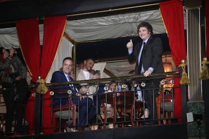 El candidato Manuel Adorni y el presidente Javier Milei, en el palco del teatro Señor Tango durante el desfile de Roberto Piazza