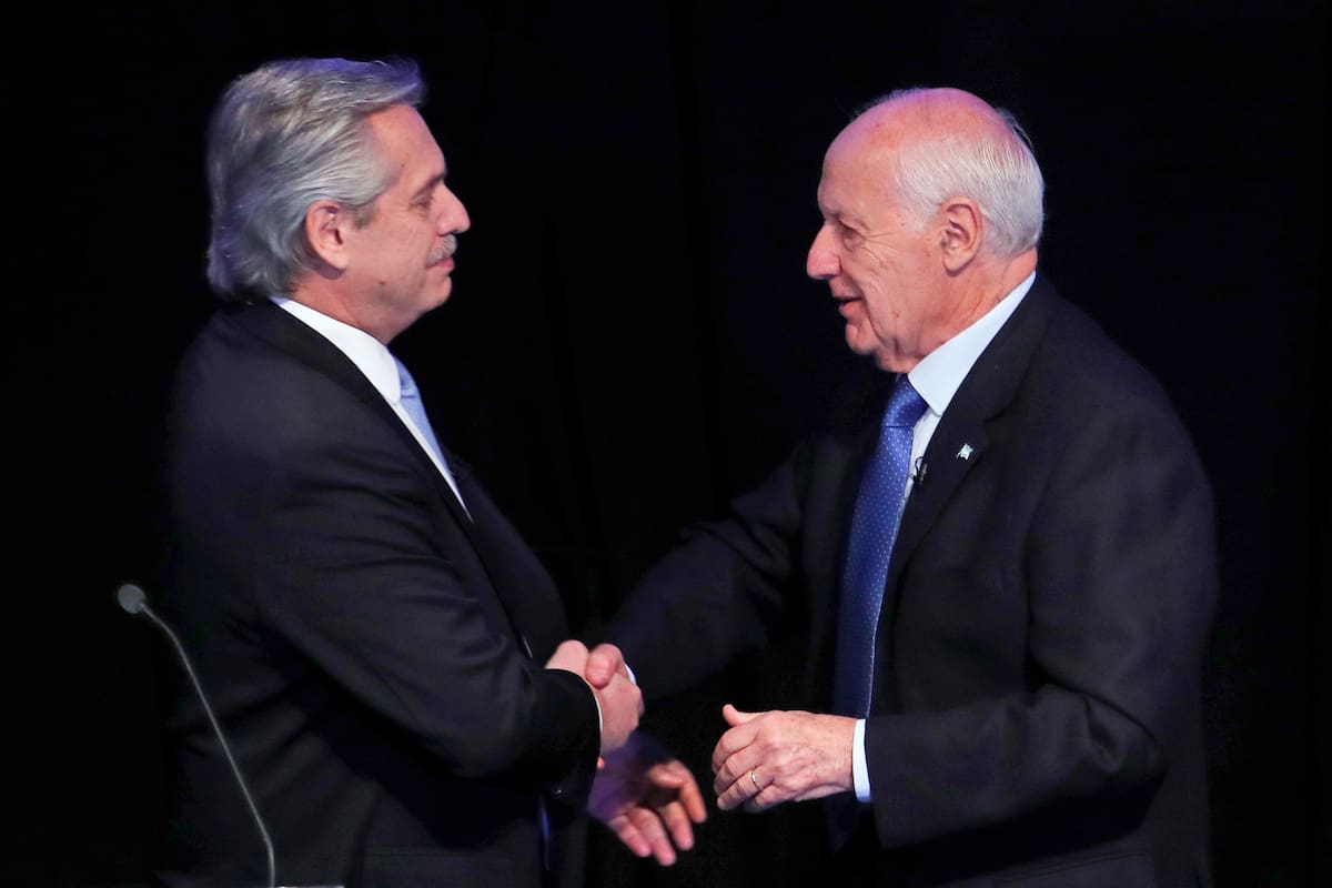 El candidato presidencial Alberto Fernández con el partido "Frente de Todos", a la izquierda, se da la mano con el candidato rival Roberto Lavagna con el partido "Consenso Federal" después de que participaron en un debate de candidatos presidenciales en Buenos Aires, Argentina, e