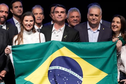 El candidato presidencial brasileño Flavio Bolsonaro (cent) posa para una foto con su esposa Fernanda Bolsonaro (izq), su compañero de fórmula Alfredo Gaspar (der) en un evento en Brasilia, el 5 de agosto del 2026