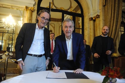 El candidato presidencial Juan Schiaretti firma el compromiso, jun to al ministro de Finanzas de Córdoba, Osvaldo Giordano