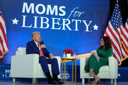 El candidato republicano a la Casa Blanca, el expresidente Donald Trump, habla con la cofundadora de Moms for Liberty Tiffany Justice durante un acto en la convención anual del grupo en Washington, el 30 de agosto de 2024. (AP Foto/Mark Schiefelbein)