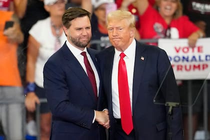 El candidato republicano a la vicepresidencia, el senador republicano por Ohio JD Vance, a la izquierda, y el candidato republicano a la presidencia, el expresidente Donald Trump, se dan la mano en un acto de campaña en la Universidad Estatal de Georgia, en Atlanta, el sábado 3 de agosto de 2024.