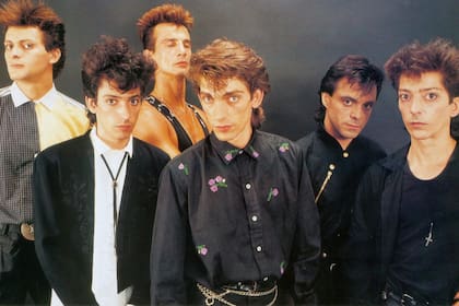 El cantante, al frente de Virus y rodeado por sus dos hermanos, Marcelo a la izquierda y Julio a la derecha