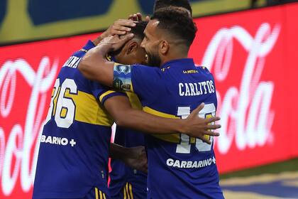 El capitán abraza a Agustín Almendra, la figura del triunfo, y a Cristian Medina, el autor, en el festejo del primer gol de Boca.