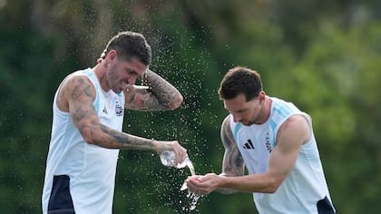 El capitán de Argentina, Lionel Messi, y Rodrigo De Paul se refrescan durante el entrenamiento para el partido contra Cabo Verde en 16avos del Mundial