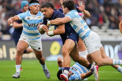 El capitán escocés Sione Tuipulotu avanza entre Gonzalo García y el debutante Faustino Sánchez Valarolo; Escocia encontró agujeros por el centro y por las puntas.