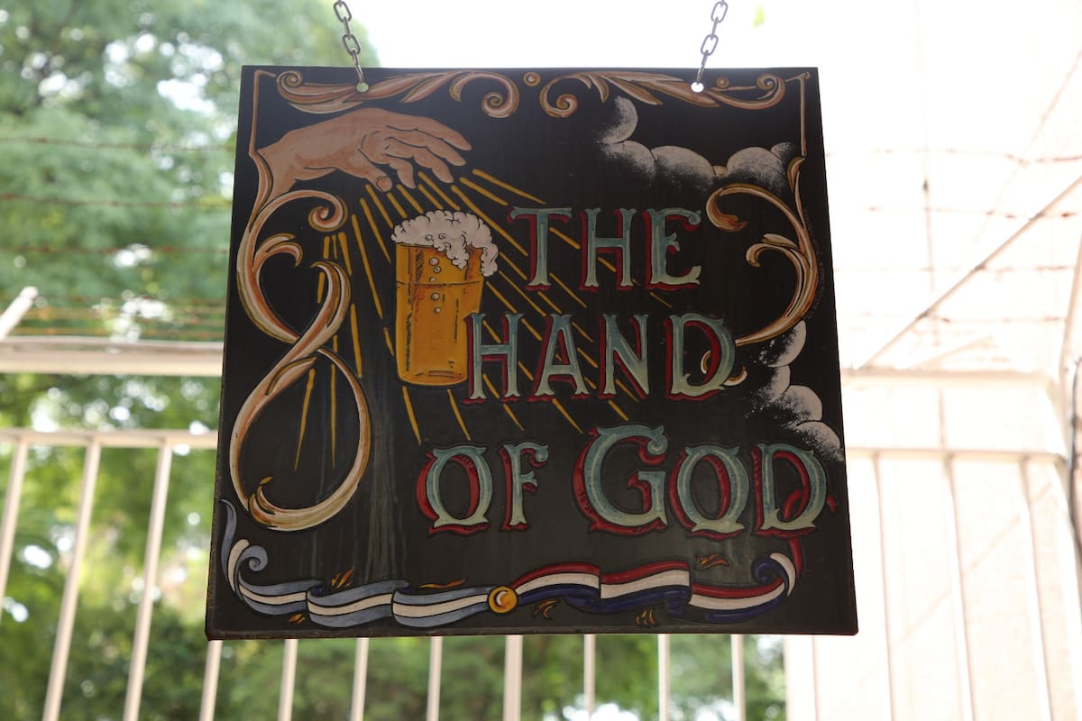 El cartel, pintado con el clásico fileteado porteño, indica el único acceso al pub británico
