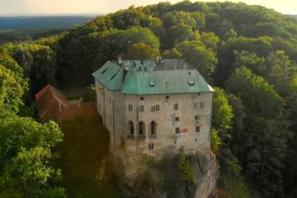 El castillo en un cerro boscoso, inmerso en un paisaje solitario a una hora de Praga