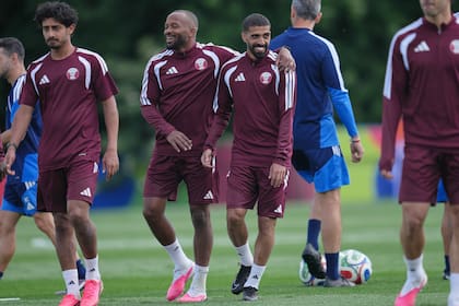 El catarí Hassan Al-Haydos (derecha) es abrazado durante una sesión de entrenamiento en la víspera del partido de fútbol de la Copa Mundial de su equipo contra Canadá
