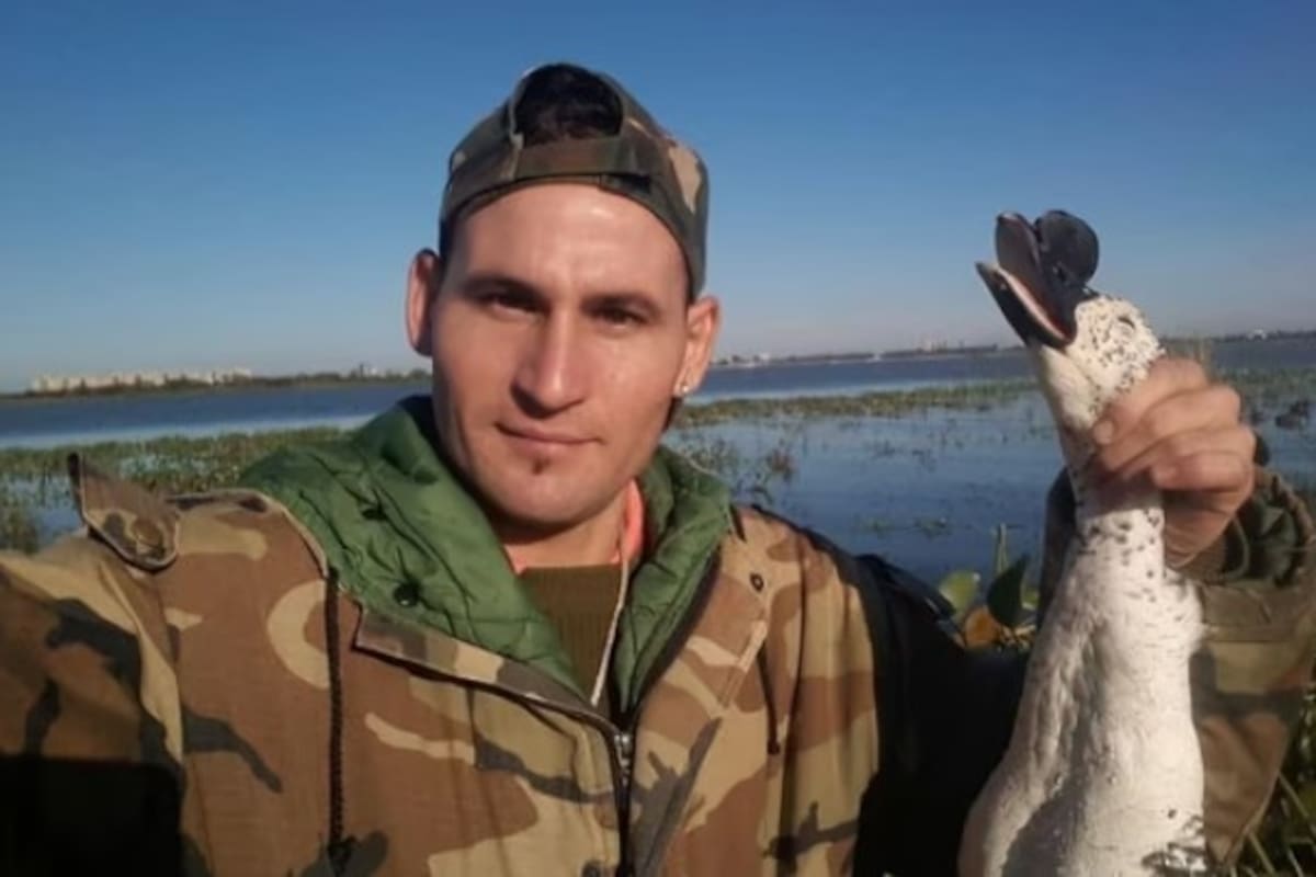 El cazador sostiene un pato crestudo