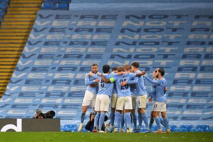 El centrocampista argelino de Manchester City Riyad Mahrez es abrazado por sus compañeros después de su segundo gol en el partido de vuelta de la semifinal de la Liga de Campeones contra Paris Saint-Germain.