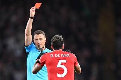 El centrocampista argentino del Atlético de Madrid, Rodrigo De Paul, recibe una tarjeta roja del árbitro alemán Felix Zwayer durante el partido de fútbol del grupo E de la Liga de Campeones de la UEFA