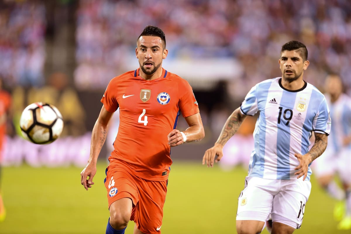 El chileno Mauricio Isla (izq.) Y el argentino Ever Banega miran el balón durante la final de la Copa América Centenario en East Rutherford, Nueva Jersey, Estados Unidos, el 26 de junio de 2016.