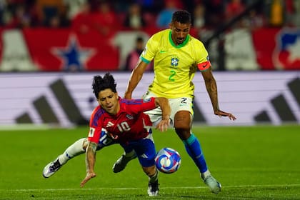 El chileno Víctor Dávila (izquierda) y el brasileño Danilo disputan el balón durante el partido de las eliminatorias del Mundial, el jueves 10 de octubre de 2024, en Santiago, Chile. (AP Foto/Esteban Félix)