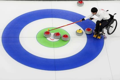 El chino Jinqiao Yang compite en el curling mixto sobre silla de ruedas ante Italia, durante los Jue