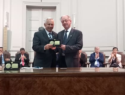 El cirujano infantil Cristóbal Papendieck (dreecha), al recibir el premio del decano de la Facultad de Ciencias Médicas de la Universidad del Salvador, Daniel Martínez.