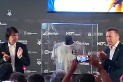 El coleccionista argentino Marcelo Ordás aplaude junto con Lothar Matthäus; en el medio, la camiseta de Maradona