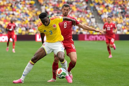 El colombiano Jhon Lucumí defiende la pelota ante la presión de Remo Freuler. (AP Photo/Lindsey Wasson)