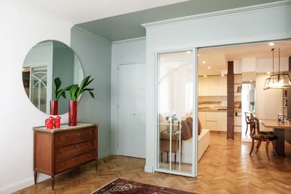 El color oscuro en el extremo del living (que se logó con una mano de ‘Gris Borroso’ y otra de ‘Día Ventoso’ de Alba) se realza con el rojo brillante de los objetos deco.