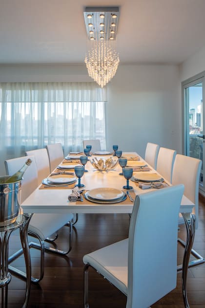 El comedor –con una mesa para ocho comensales- se funde con el living en un concepto abierto en forma de L, abrazando el balcón