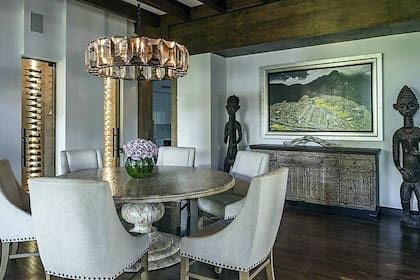 El comedor cuenta con una mesa redonda, cava para vinos y decorado inca y azteca